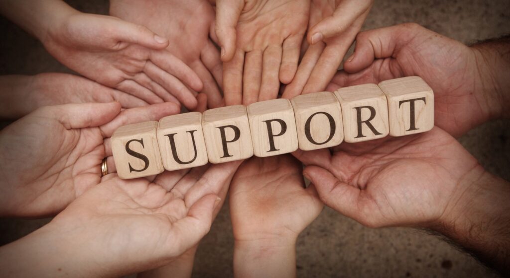 Mental Health Blog Multiple hands holding up wooden blocks displaying the word "Support"