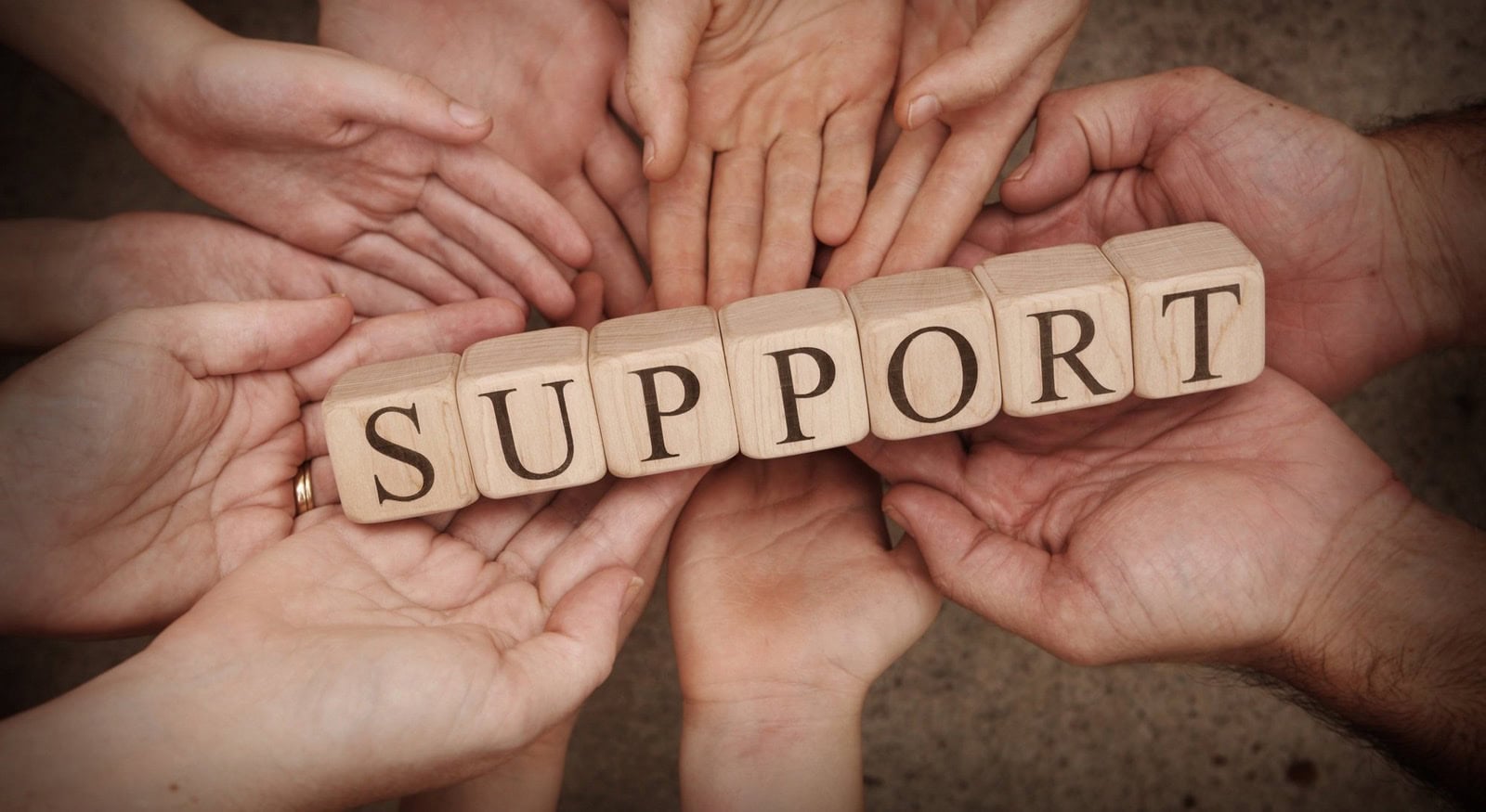 Mental Health Blog Multiple hands holding up wooden blocks displaying the word "Support"