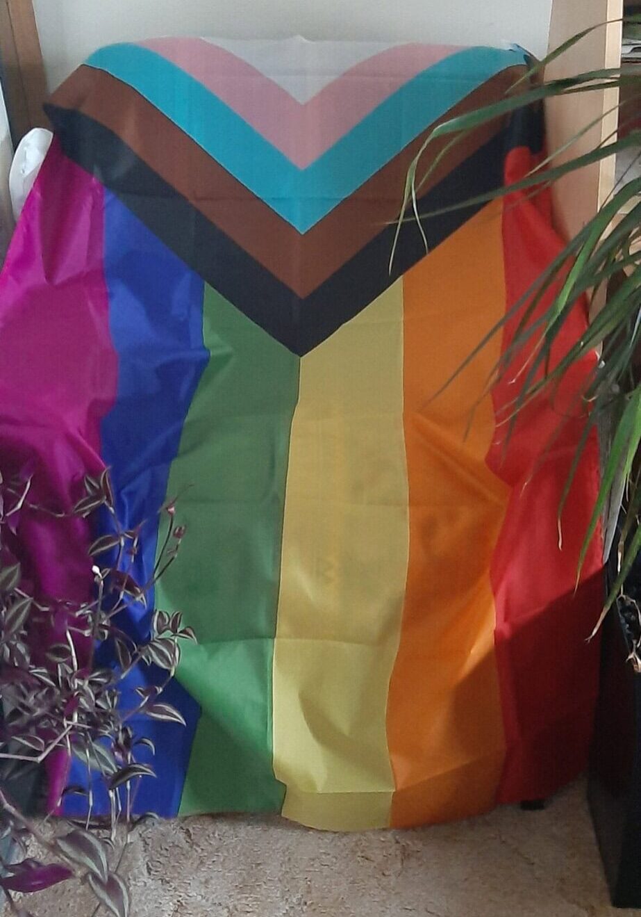 LGBTQ pride flag draped over a chair, highlighting inclusive therapy.